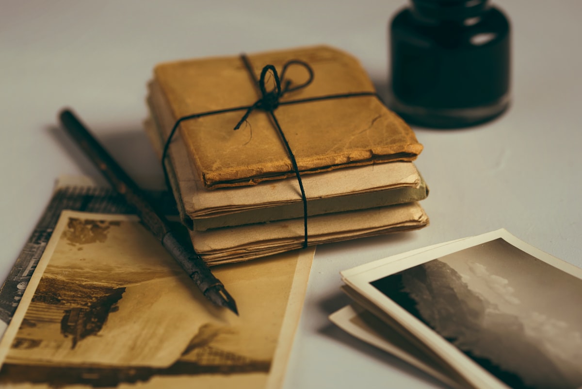 Documentos antiguos atados y tintero sobre un escritorio