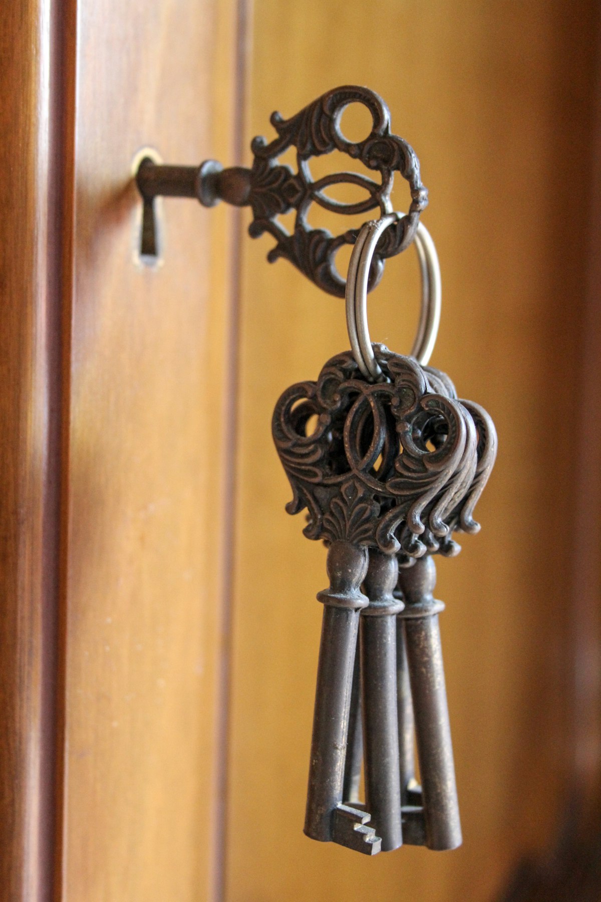 Juego de llaves antiguas colgando de la cerradura de una puerta